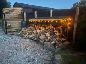 a pile of fire wood under a building with lights at Thistlebank Yurt in Llangollen