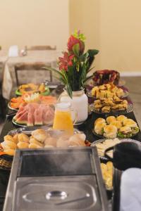 um buffet com muitos pratos de comida numa mesa em Diamantina Palace Hotel em Morro do Chapéu