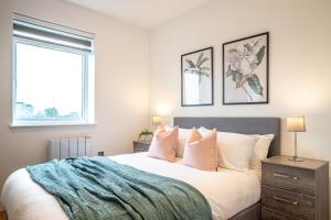 um quarto com uma grande cama branca e 2 janelas em Deluxe & Chic 1 & 2 Bed Apts near Heathrow, Legoland, & Windsor Slough em Slough