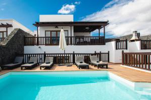 a villa with a swimming pool and a house at Villa Vista Reina - Luxury 6 Bedroom - Heated Pool- Views - Pool Table - Vista Lobos - Playa Blanca in Playa Blanca