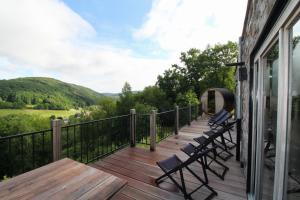 una terraza con sillas y una mesa en una casa en Suites de la vallée 6 en Érezée