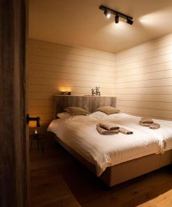 een slaapkamer met een bed met twee handdoeken erop bij Suites de la vallée 6 in Érezée