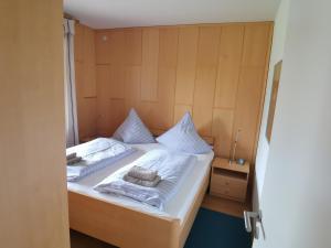 Schlafzimmer mit einem Bett mit weißer Bettwäsche und Handtüchern in der Unterkunft Haus Antje in Norddeich