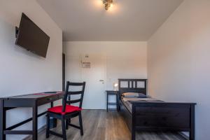 ein Schlafzimmer mit Schreibtisch, Bett und einem Schreibtisch mit Computer in der Unterkunft Gästehaus Olympia Wilhelmshaven - Moderne Einzelzimmer mit eigenem Bad für Monteure in Schortens