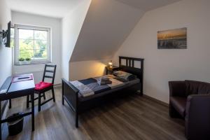 a bedroom with a bed and a desk and a chair at Gästehaus Olympia Wilhelmshaven - Moderne Einzelzimmer mit eigenem Bad für Monteure in Schortens