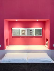 una camera da letto con un letto e una parete rosa di L'angolo di mare [Centro di Sirolo] a Sirolo