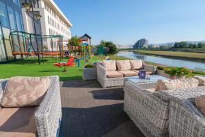a patio with two wicker couches and a playground at Malak Regency Hotel in Sarajevo