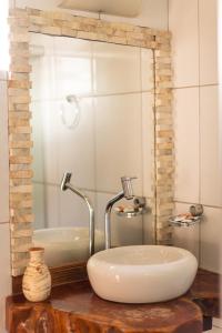 a bathroom with a white sink and a mirror at Pousada Vila Bacana in São Miguel do Gostoso