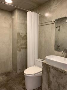een badkamer met een wit toilet en een wastafel bij Longzhu Guesthouse in Bangkok