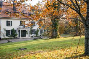 a white house with a tree in the yard at Chateau d'Echenevex - Luxury Escape near Geneva in Échenevex