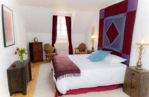 Dormitorio con cama grande y cabecero colorido en Chateau d'Echenevex - Luxury Escape near Geneva, en Échenevex