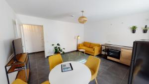 a living room with a white table and yellow chairs at Travel Art Boardinghouse (Lazarettstr.) in Neuruppin