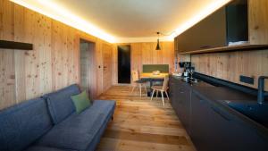 ein Wohnzimmer mit einem blauen Sofa und einer Küche in der Unterkunft Pliegermoar in Völs am Schlern in Vols am Schlern
