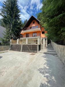 an orange house with a fence in front of it at Apartmani Megara Vlasic in Šišava