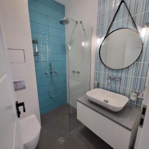 a bathroom with a sink and a shower with a mirror at New luxury apartment next to subway with garage in Sofia