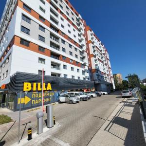a parking lot with cars parked in front of a building at New luxury apartment next to subway with garage in Sofia