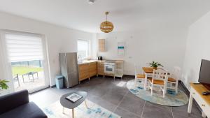 a kitchen and living room with a table and a kitchen and a dining room at Travel Art Boardinghouse (Lazarettstr.) in Neuruppin