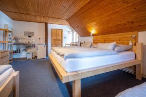 a bedroom with a large bed with a wooden ceiling at Penzion Koucký in Bedřichov +89 photos