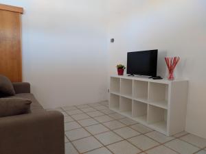 a living room with a tv on a white cabinet at RESIDENZA GATTO SILVESTRO A 2 MINUTI DAL MARE E DALLA FIERA in Rimini