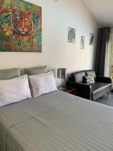 a bedroom with a bed with a painting of a tiger at LA PASSIFLORE in La Londe-les-Maures