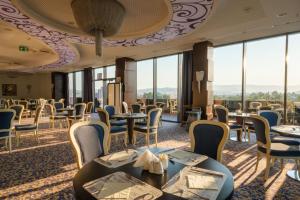 فندق ملاك ريجنسي في سراييفو: مطعم بطاولات وكراسي ونوافذ كبيرة