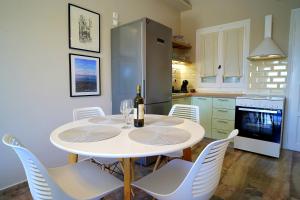 kuchnia ze stołem, krzesłami i lodówką w obiekcie Antàma Apartments w mieście Skriperón
