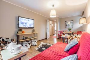 a living room with a red couch and a table at Apartament Tosia Zakopane in Zakopane