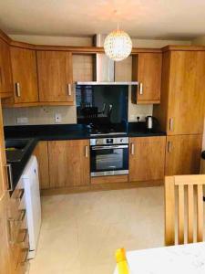 a kitchen with wooden cabinets and a stove top oven at Semi-detached Armagh House in Armagh