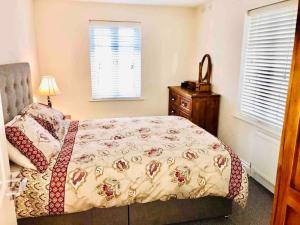 a bedroom with a bed and a dresser and a window at Semi-detached Armagh House in Armagh