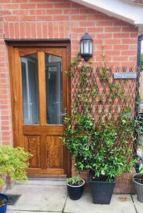 a brick house with a wooden door and potted plants at Semi-detached Armagh House in Armagh