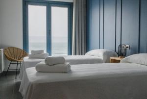um quarto de hotel com duas camas com toalhas em Restaurante Hostal Náutico de Razo em Carballo