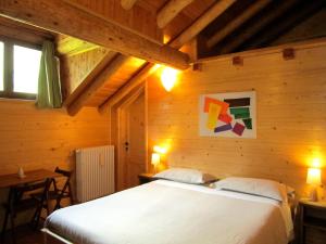 a bedroom with a bed in a wooden room at Ca dal Cros in Campertogno