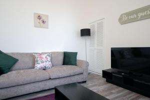 a living room with a couch and a flat screen tv at Baker Apartment - Lovely 2-bedroom apartment in Aberdeen City in Aberdeen
