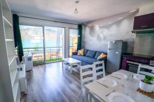 cocina y sala de estar con sofá y mesa en CABANA & Fenêtre sur Lac - Terrasse & Parking, en Tresserves