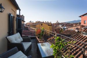 einen Balkon mit einem Tisch und Stühlen auf einem Gebäude in der Unterkunft Hotel Palazzo Alexander in Lucca