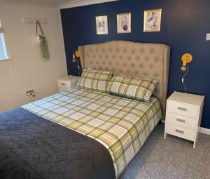 a bedroom with a bed and a blue wall at 1 bedroom apartment with own entrance and parking space in Huntingdon