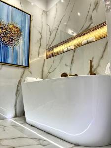 een witte badkamer met een laptop op een aanrecht bij MONDRIAN Luxury Suites UNESCO Old Town in Warschau