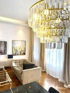 a living room with a couch and a chandelier at MONDRIAN Luxury Suites UNESCO Old Town in Warsaw