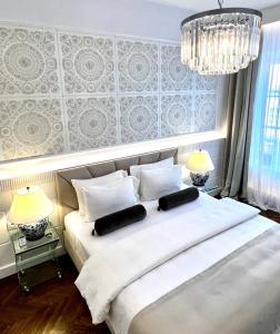 a bedroom with a large white bed with two lamps at MONDRIAN Luxury Suites UNESCO Old Town in Warsaw