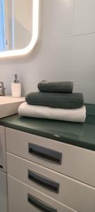 a bathroom with a counter with towels and a sink at Appartamento DeLuxe con parcheggio gratuito in Segrate