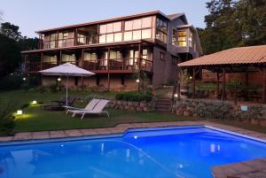a house with a pool in front of it at Pumula Lodge 4 Star B&B Knysna in Knysna