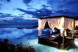 ein Resort mit einem Bett und dem Meer in der Nacht in der Unterkunft Centara Mirage Resort Mui Ne in Mui Ne