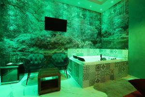 Alcova Suite&Relax في إبولي: حمام مع حوض و كرسيين وتلفزيون