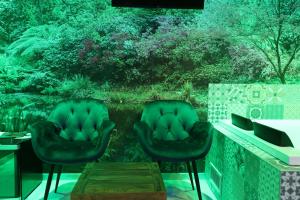 Alcova Suite&Relax في إبولي: كرسيان سودان يجلسون على شرفة مع غابة