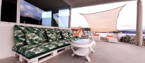 un soggiorno con divano e un tavolo sul balcone. di Melrouse Place House a Pontevedra