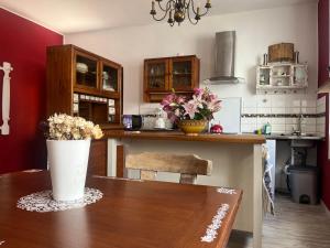 a kitchen with a wooden table with flowers on it at Haus Bell in Trippstadt