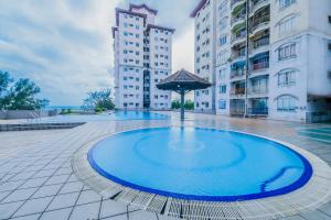 een groot blauw zwembad in het midden van een gebouw bij OYO Home 90466 JC Sunshine Bay Resort Apartment Port Dickson in Port Dickson