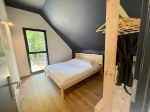 een kleine slaapkamer met een bed en een raam bij L’Éterle, maison de montagne in Aucun