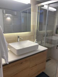 a bathroom with a white sink and a shower at Villa Massari in Haraki
