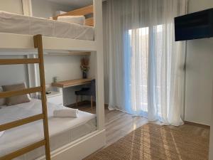sypialnia z łóżkiem piętrowym, biurkiem i oknem w obiekcie Villa Massari w mieście Charaki